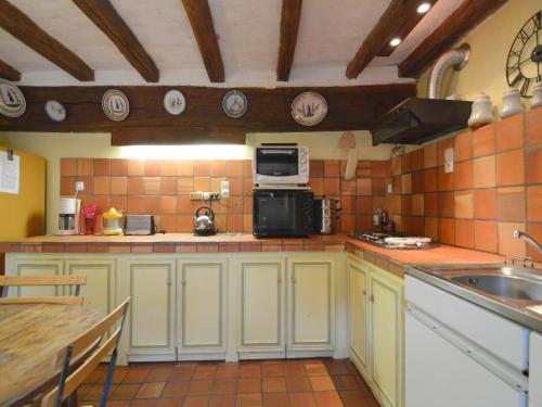 a kitchen with green cabinets and a sink and a microwave at Saint-Paul Pool Retreat in Saint-Paul-du-Bois