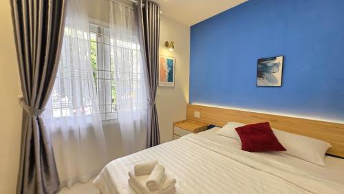 Un dormitorio con una cama blanca y una ventana. en B House, en Ho Chi Minh