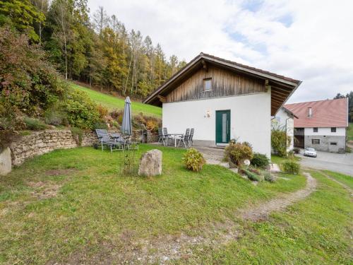 a cottage with a table and chairs in a yard at Beautiful holiday home in Viechtach with views in Viechtach
