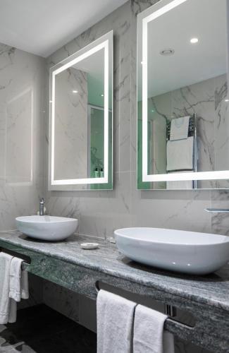 a bathroom with two sinks and a large mirror at Rivoli Boutique Hotel in Florence