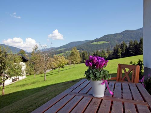 a vase of flowers sitting on a wooden table at Charming Holiday Home in Hüttau with Barbecue in Hüttau