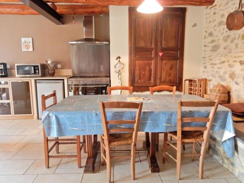a dining room with a blue table and chairs at Holiday Home in Saint-Beauzire with Garden and Private Terrace in Saint-Beauzire