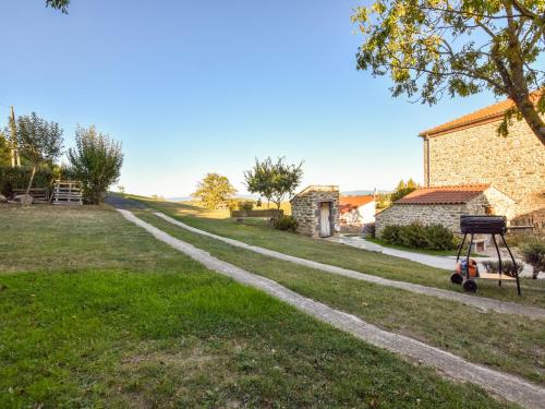 a path in a yard next to a house at Holiday Home in Saint-Beauzire with Garden and Private Terrace in Saint-Beauzire