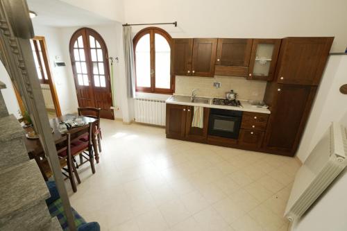 a kitchen with wooden cabinets and a table with chairs at U Ciousu by Ligurian Life APPARTAMENTI IN AGRITURISMO in Vallebona