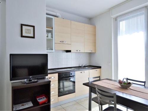 una cucina con un tavolo e una televisione e un tavolo e una sala da pranzo di Simplistic apartment in Dervio with balcony terrace a Dervio