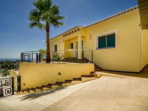 a house with stairs and a palm tree at Unique villa in Moraira with infinity pool in Moraira