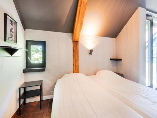 a bedroom with a white bed and a window at Atmospheric country house in Asten on a golf course in Asten