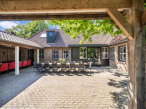 a patio with chairs and a table in front of a building at Atmospheric country house in Asten on a golf course in Asten