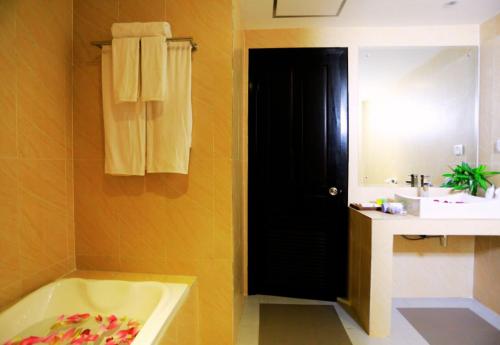 a bathroom with a black door and a sink and a tub at Angkor Land House in Phumĭ Réach Born