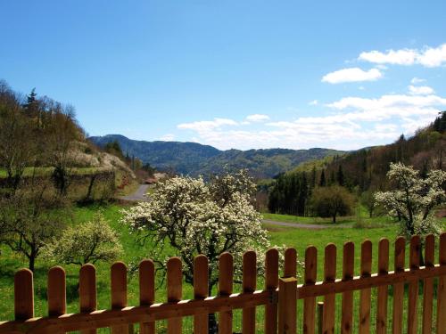 une clôture en bois avec vue sur la montagne dans l'établissement Cozy Countryside Escape in Auvergne, à Vachelerie