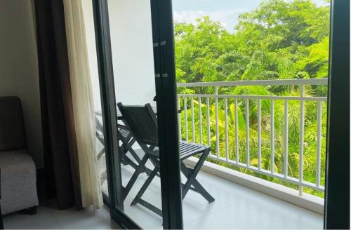 a chair sitting on a balcony looking out the window at Angkor Land House in Phumĭ Réach Born