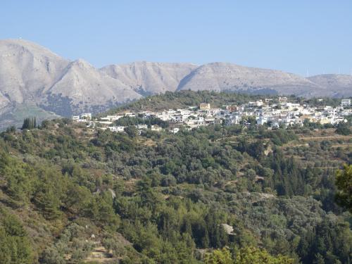 a town on a hill with mountains in the background at Holiday Home with Garden in Kritinia in Kritinía