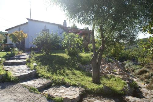 a tree in front of a house with some rocks at Holiday Home with Garden in Kritinia in Kritinía