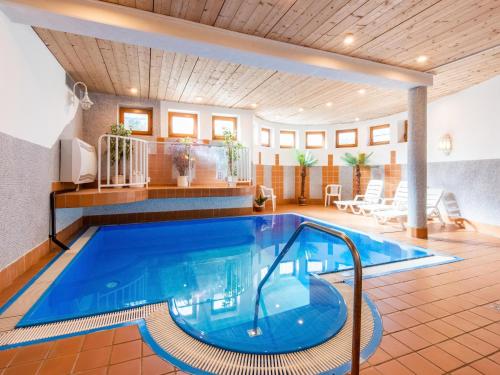 a large swimming pool in a room with a pool at Pretty Apartment in Oberau with Infrared Sauna in Oberau
