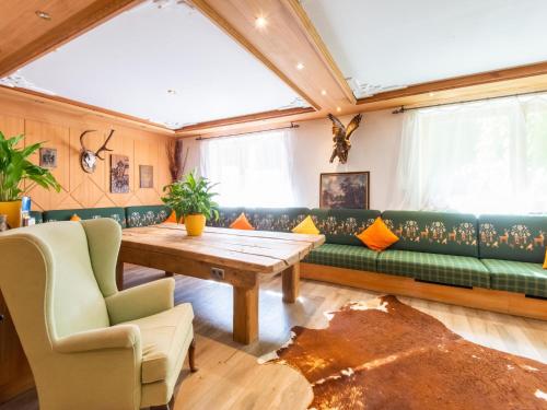 a living room with a green couch and a wooden table at Pretty Apartment in Oberau with Infrared Sauna in Oberau