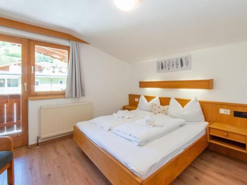 a bedroom with a bed with white sheets and a window at Pretty Apartment in Oberau with Infrared Sauna in Oberau