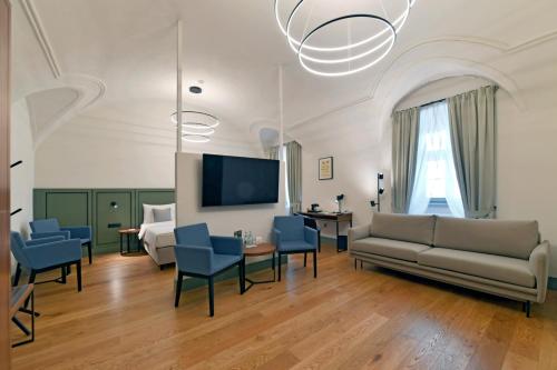 a living room with a couch and chairs and a tv at Herbal Hotel Wrocław in Wrocław