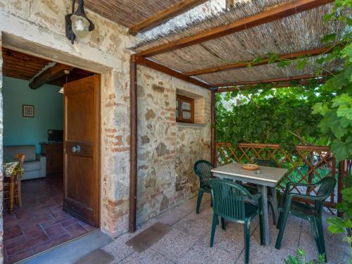 a patio with a table and chairs and an open door at Scenic Apartment in Casole d'Elsa with Pool in Casole dʼElsa
