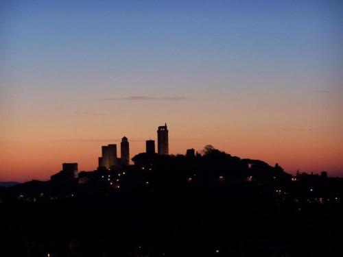 a silhouette of a city skyline at sunset at Scenic Apartment in Casole d'Elsa with Pool in Casole dʼElsa