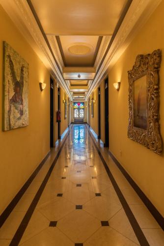 an empty hallway with a tile floor and paintings on the walls at Golden Tulip Stone Town Boutique in Zanzibar City