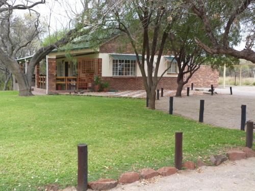 a brick building with trees in front of it at Woodlands Stop Over and Lodge in Francistown