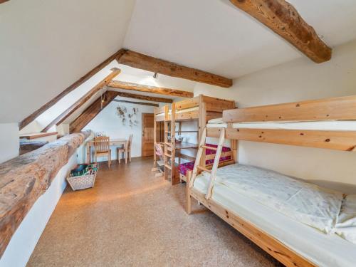 two bunk beds in a room with a table at Historic Farmhouse in Hohnebostel with Garden near Lake in Langlingen