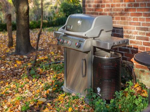 a grill and a trash can next to a brick building at Historic Farmhouse in Hohnebostel with Garden near Lake in Langlingen