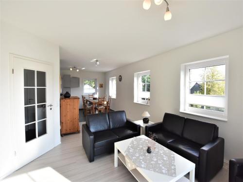 a living room with a couch and a table at Charming Apartment in Oldenburg in Holstein with Terrace in Oldenburg in Holstein