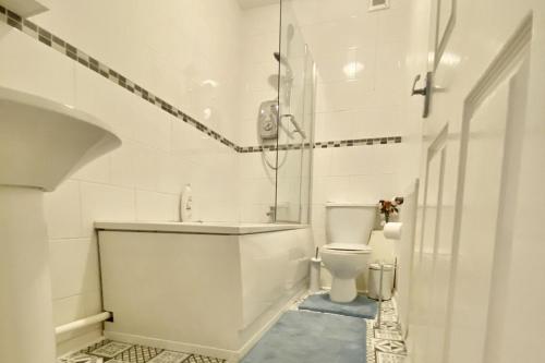 ein weißes Badezimmer mit Badewanne und Toilette in der Unterkunft House near Cardiff City Centre in Cardiff