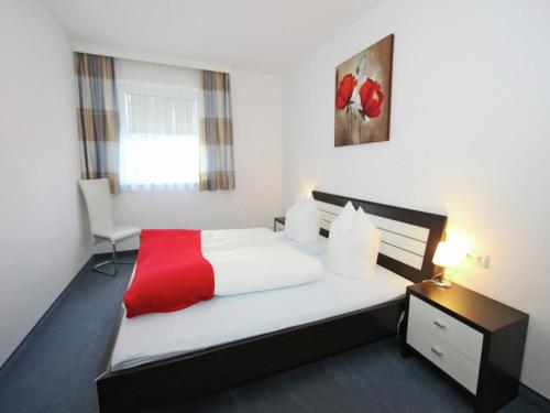 ein Schlafzimmer mit einem Bett mit einer roten Decke in der Unterkunft Modern Apartment in Fiss at Ski Bus Stop in Fiss