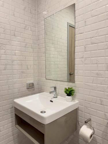 a white bathroom with a sink and a mirror at ไรท์ อพาร์ทเม้นท บาย กู๊ดดี in Ban Liap