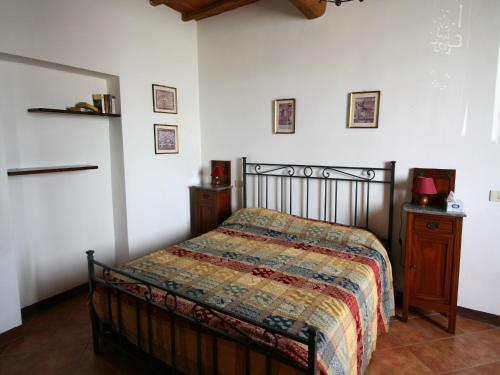 a bedroom with a bed and a wooden night stand at Traditional Farmhouse in Toscana with Swimming Pool in San Lorenzo a Merse