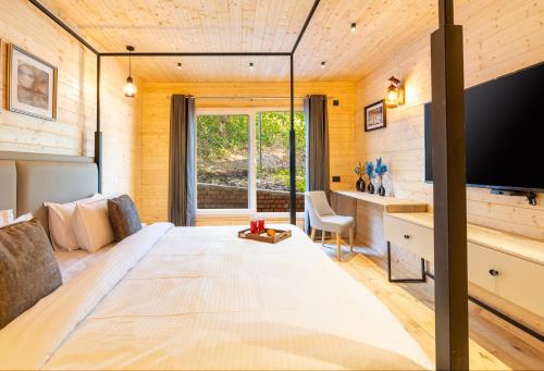 a bedroom with a large bed with a large television at SaffronStays The Woods - Sal Villa in Dehradun