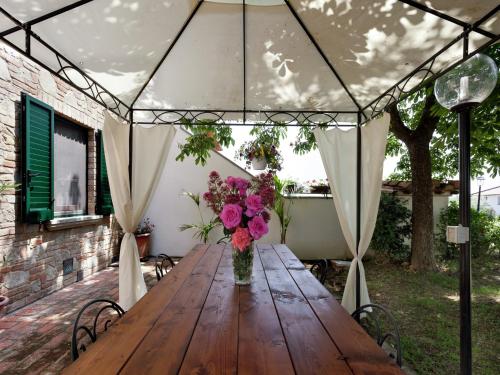 a wooden table in a tent with a vase of flowers at Modern Holiday Home in Foiano della Chiana with Pool in Foiano della Chiana