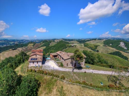 サンタンジェロ・イン・ヴァードにあるFlat on a farm with swimming pool and many activitiesの丘の上の家屋