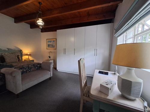 a bedroom with a bed and a table with a lamp at Fiore Guest Accommodation in Greyton