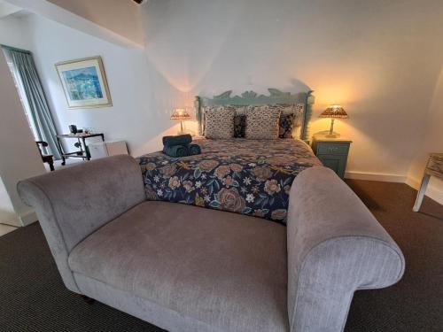 a bedroom with a large bed and a couch at Fiore Guest Accommodation in Greyton