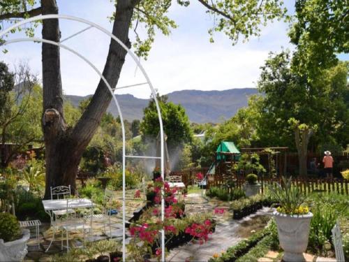 a garden with a white arbor and flowers at Fiore Guest Accommodation in Greyton