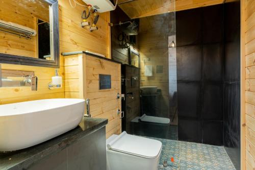 a bathroom with a sink and a shower and a toilet at SaffronStays The Woods - Sal Villa in Dehradun