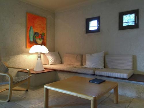 ein Wohnzimmer mit einem Sofa, einem Tisch und einer Lampe in der Unterkunft Villa in Tourtour with Swimming Pool in Tourtour