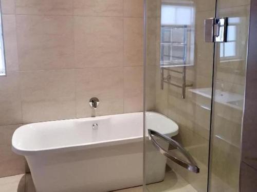 a bathroom with a white tub and a toilet at Fiore Guest Accommodation in Greyton
