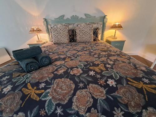 a bedroom with a large bed with a floral bedspread at Fiore Guest Accommodation in Greyton