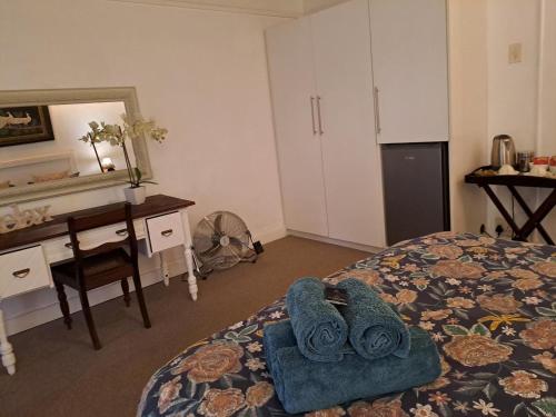 a bedroom with a bed with towels on it at Fiore Guest Accommodation in Greyton