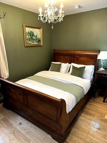 a large bed in a bedroom with a green wall at Station Cottage 4 Bed Cottage Ev Free Parking in Langwathby