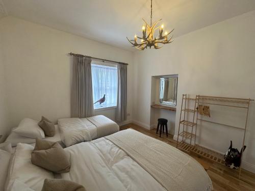 a bedroom with a bed and a chandelier at Station Cottage 4 Bed Cottage Ev Free Parking in Langwathby