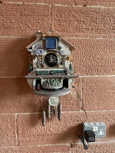 a clock on the side of a brick wall at Station Cottage 4 Bed Cottage Ev Free Parking in Langwathby