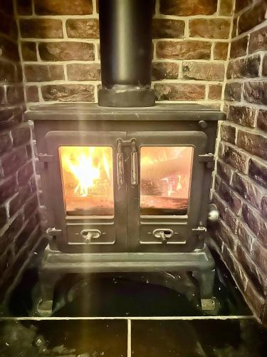 a brick oven with a fire in it at Station Cottage 4 Bed Cottage Ev Free Parking in Langwathby