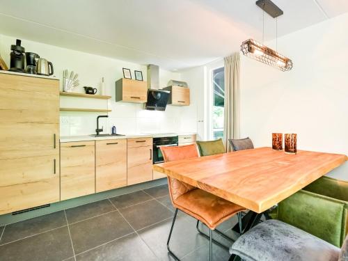a kitchen with a wooden table and chairs at House in Reutum with Jacuzzi & Forest View in Reutum