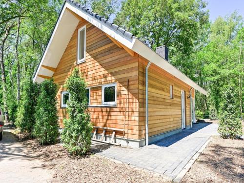 a small wooden house with a driveway at House in Reutum with Jacuzzi & Forest View in Reutum