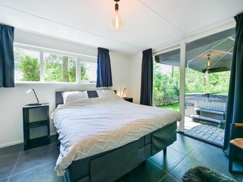 a bedroom with a bed and a large window at House in Reutum with Jacuzzi & Forest View in Reutum